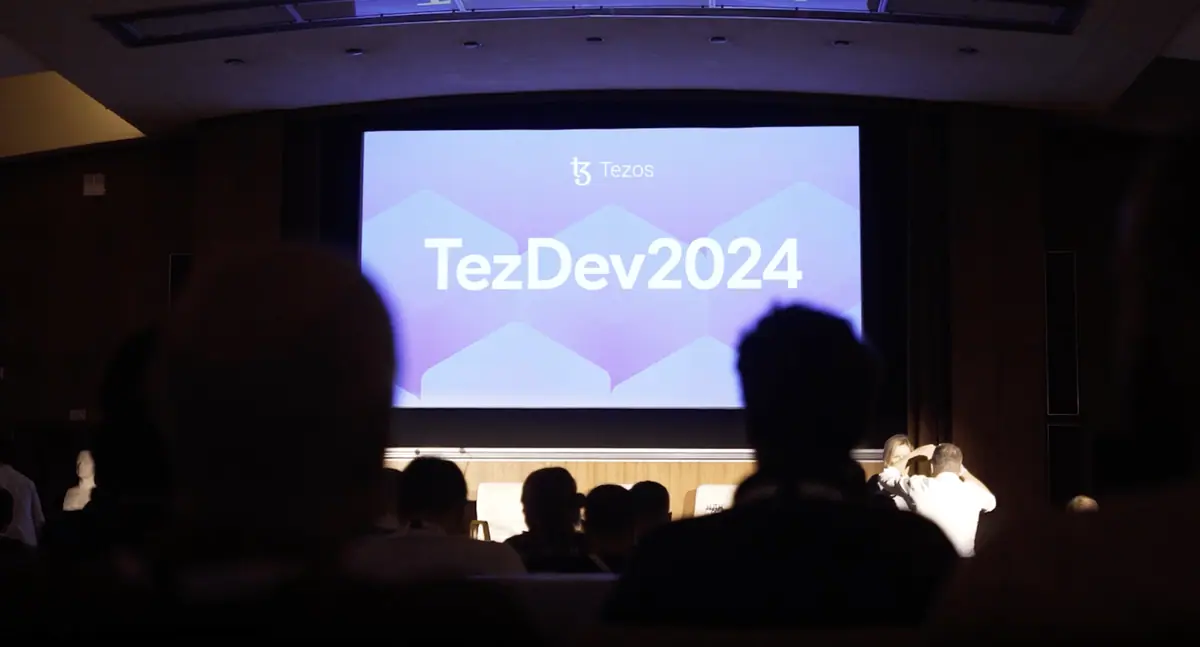 Экран презентации TezDev 2024 в зале конференции